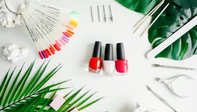 Tools of manicure set on white background as frame. Flat lay, nail polish in center.